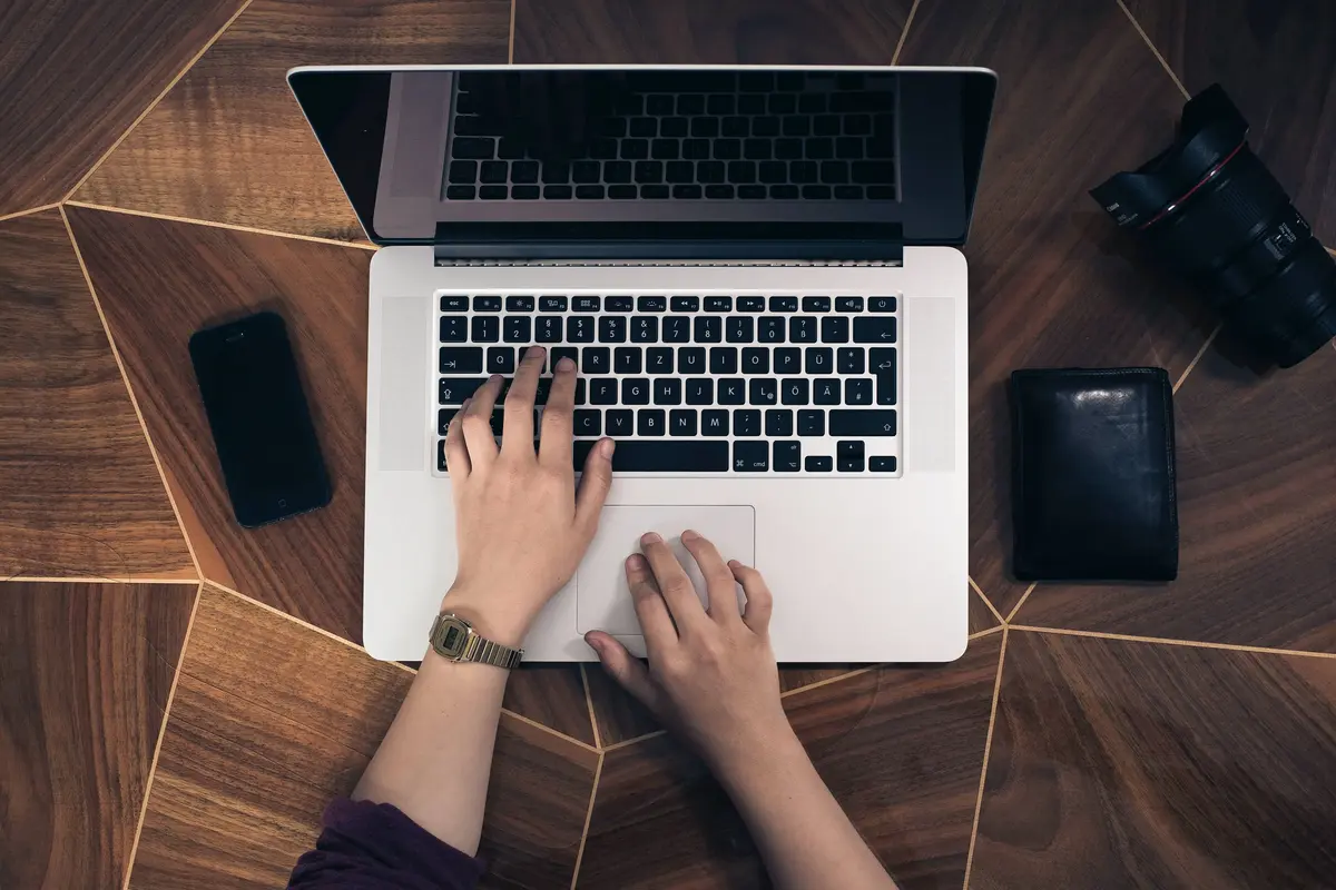 Ordinateur vue de dessus, avec des mains qui tapent sur le clavier