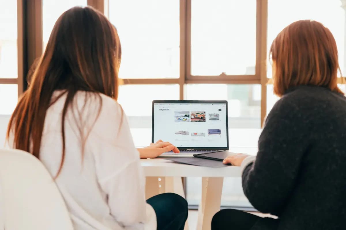 Ddeux personnes de dos, devant un ordinateur